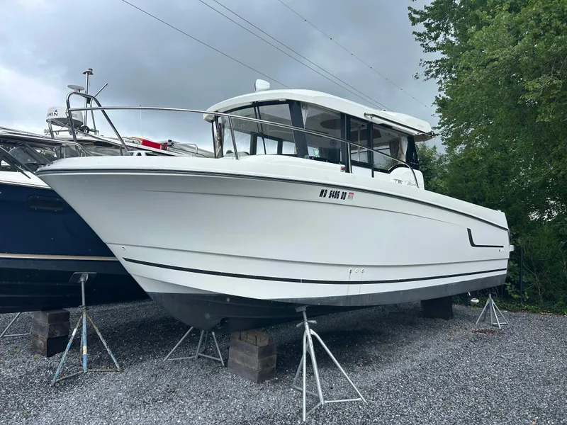 Slide: The Image of 2015 Jeanneau Merry Fisher 855 Marlin boat on stands, parked on gravel. - 0