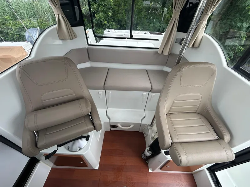 Slide: The Image of Interior of 2015 Jeanneau Merry Fisher 855 Marlin with beige seating and wood flooring. - 13