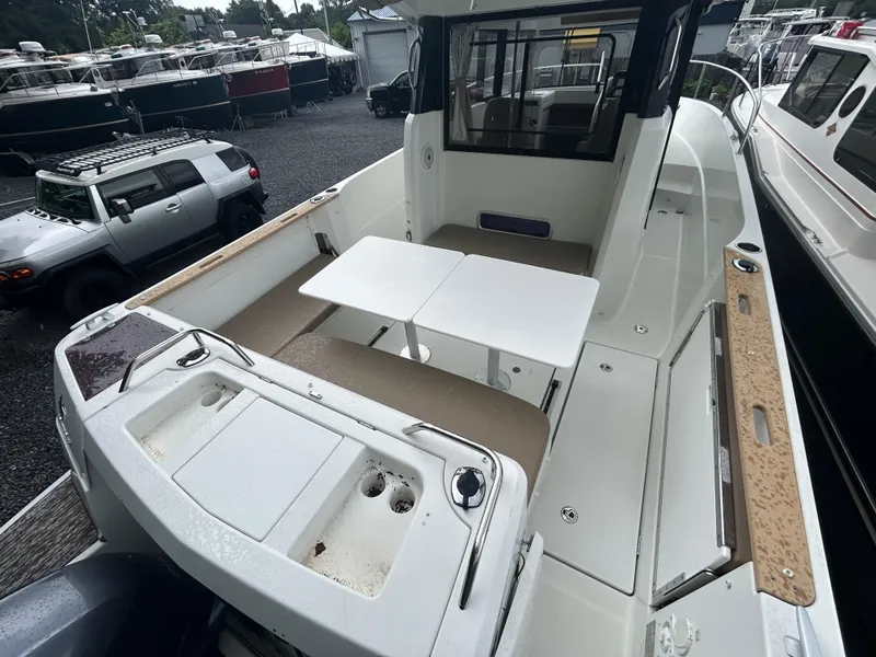 Slide: The Image of 2015 Jeanneau Merry Fisher 855 Marlin boat deck with seating and table setup. - 2