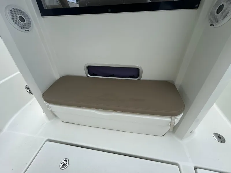 Slide: The Image of 2015 Jeanneau Merry Fisher 855 Marlin interior with cushioned bench and speakers. - 9