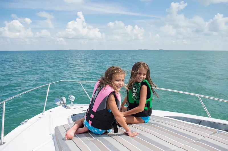 Slide: The Image of Two children on a 2019 Regal 35 Sport Coupe boat, enjoying the ocean. - 105