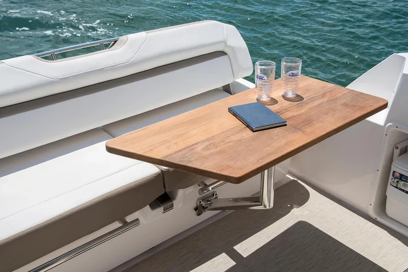 Slide: The Image of 2019 Regal 35 Sport Coupe boat interior with wooden table and seating. - 110