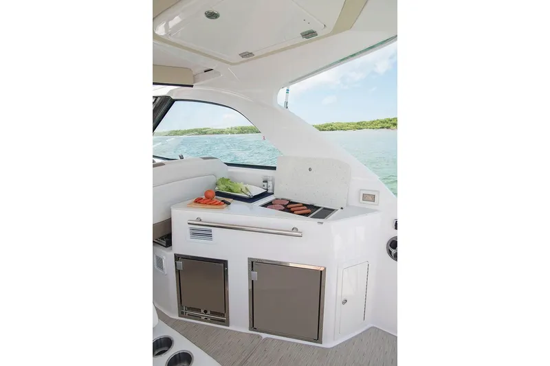 Slide: The Image of 2019 Regal 35 Sport Coupe yacht interior with kitchenette and scenic water view. - 112