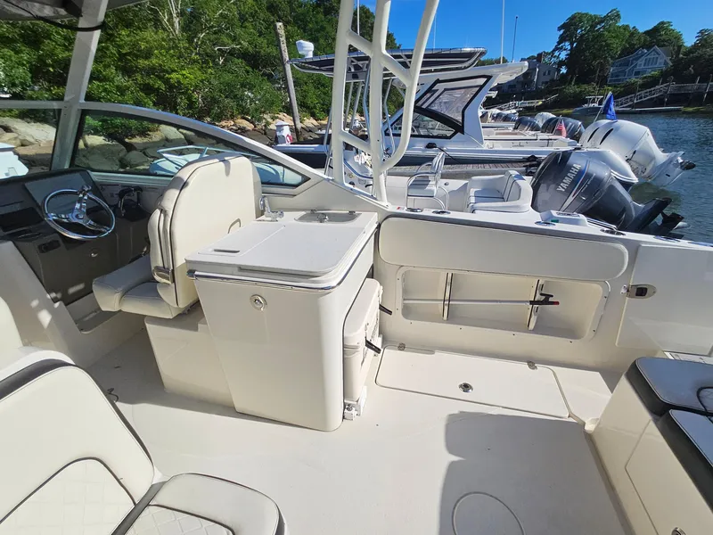 Slide: The Image of 2020 Stingray 269 DC boat interior with seating and console, docked by the water. - 17