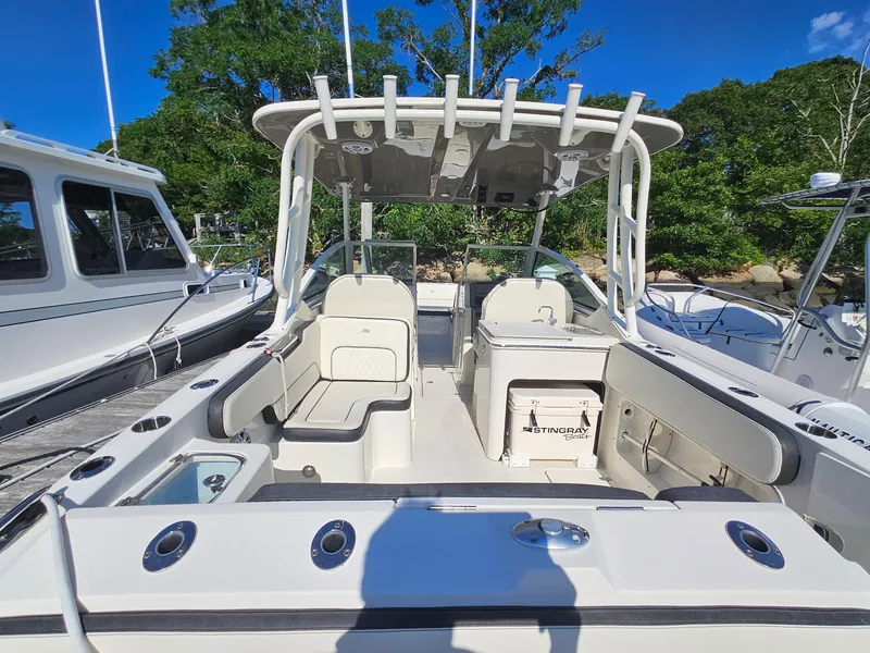 Slide: The Image of 2020 Stingray 269 DC boat interior with seating and storage, docked under clear blue sky. - 19