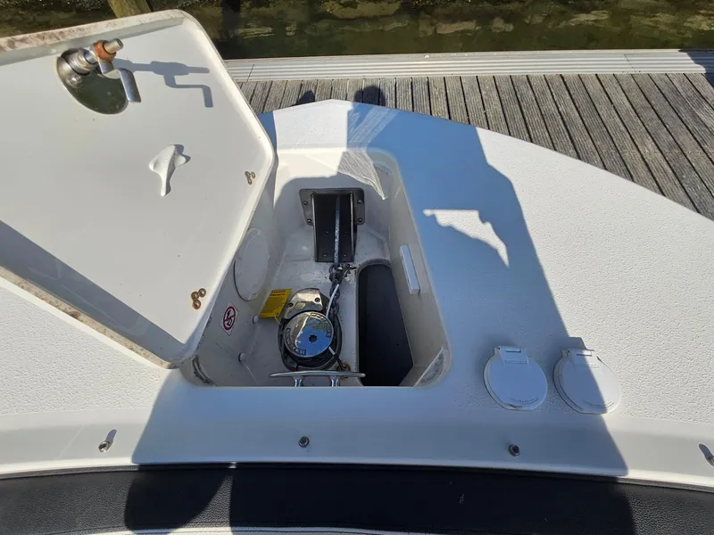 Slide: The Image of Open anchor compartment on 2020 Stingray 269 DC boat, dockside view. - 3