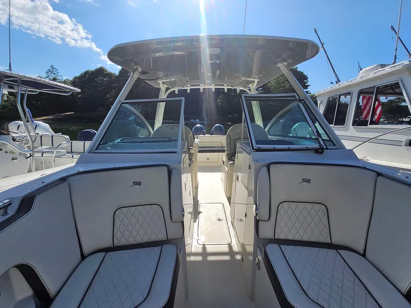 Slide: The Image of 2020 Stingray 269 DC boat interior with seating and canopy under clear blue sky. - 5