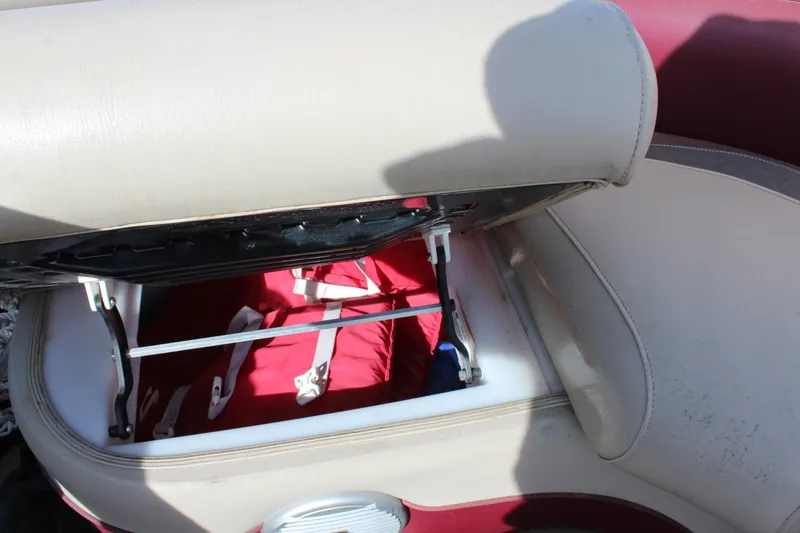Slide: The Image of Open storage compartment in 2015 Premier 220 SunSation boat with red life jacket inside. - 13