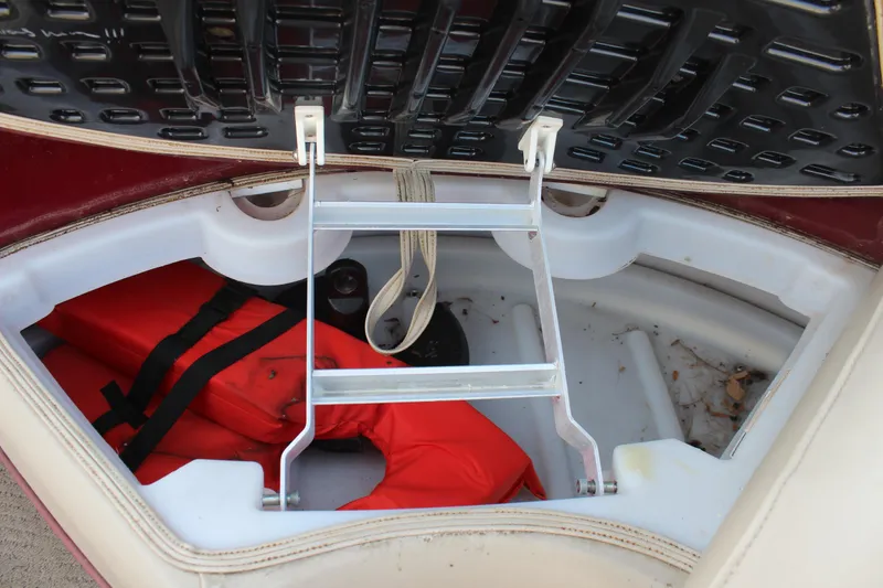 Slide: The Image of 2015 Premier 220 SunSation boat storage compartment with life jacket and ladder. - 18