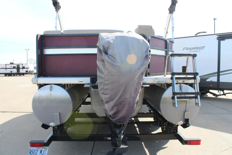 Slide: The Image of 2015 Premier 220 SunSation pontoon boat rear view with covered motor and ladder. - 6