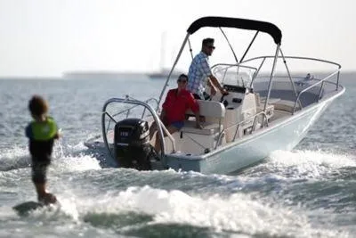 Slide: The Image of 2026 Boston Whaler 170 Montauk boat towing a water skier on a sunny day. - 10