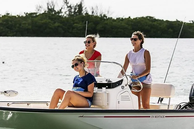 Slide: The Image of Three people enjoying a ride on a 2026 Boston Whaler 170 Montauk boat. - 9