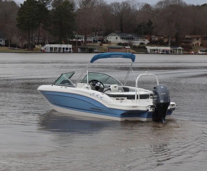 Slide: The Image of 2024 Chaparral 19 SSi OB boat on a calm lake with scenic background. - 2
