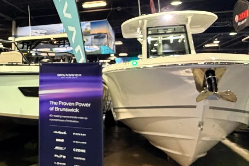 Slide: The Image of 2026 Boston Whaler 280 Outrage displayed at a boat show with Brunswick signage. - 5