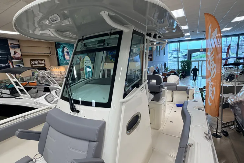 Slide: The Image of 2026 Boston Whaler 280 Outrage boat displayed in showroom with modern interior. - 7