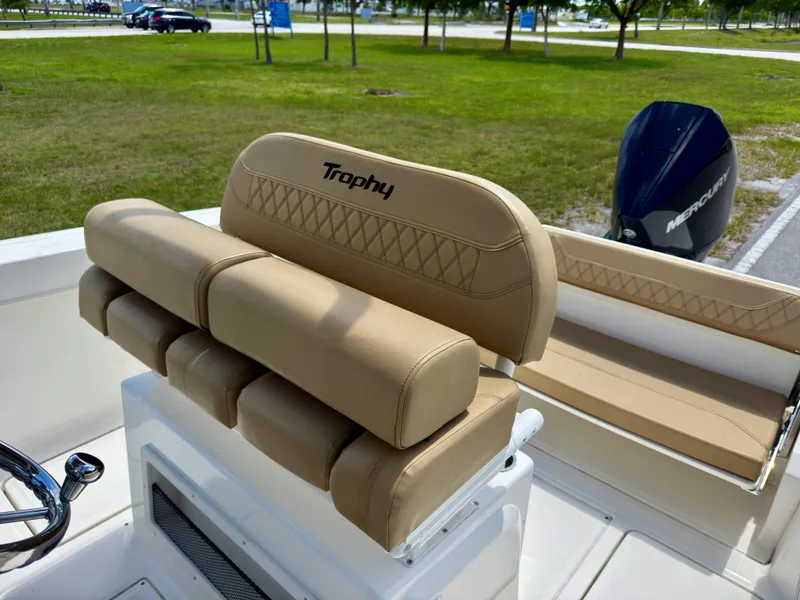 Slide: The Image of 2023 Bayliner Trophy T24CC boat interior with tan seating and Mercury engine. - 12