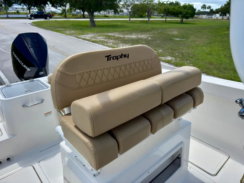 Slide: The Image of 2023 Bayliner Trophy T24CC boat seat with beige upholstery and Mercury engine in background. - 13
