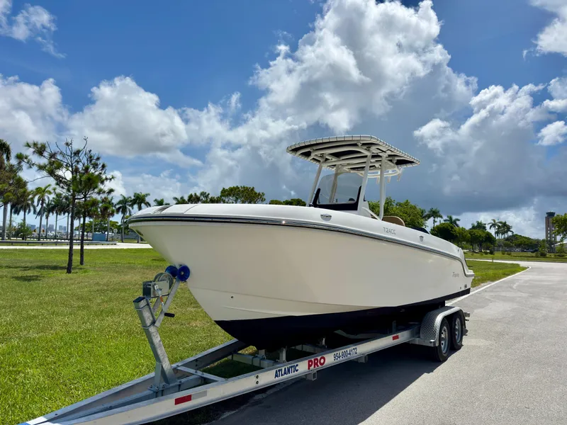 Slide: The Image of 2023 Bayliner Trophy T24CC boat on trailer under a cloudy sky. - 2