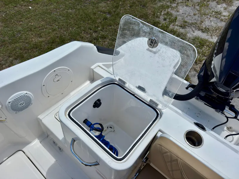 Slide: The Image of 2023 Bayliner Trophy T24CC boat with open storage compartment and visible engine. - 22