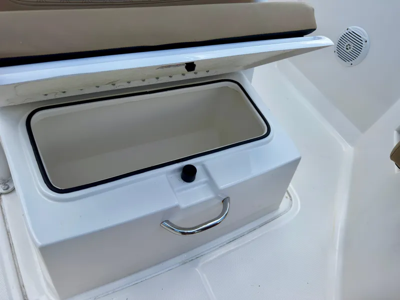 Slide: The Image of Open storage compartment on 2023 Bayliner Trophy T24CC boat, featuring a cushioned seat. - 26