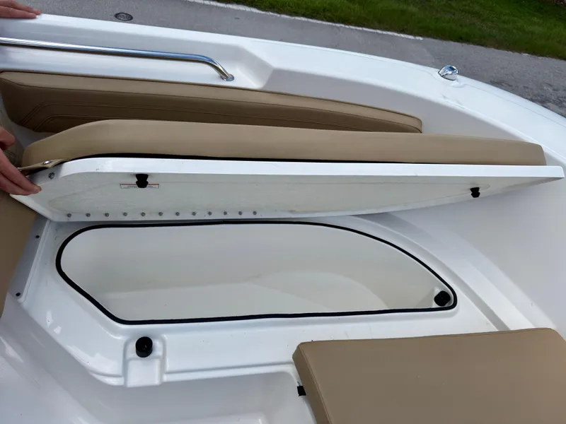 Slide: The Image of 2023 Bayliner Trophy T24CC boat storage compartment with open hatch and cushioned seating. - 27