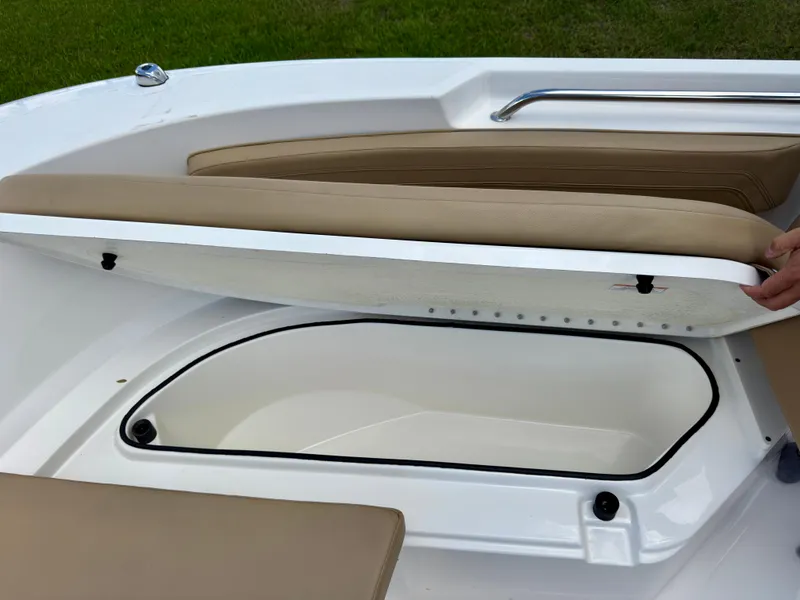 Slide: The Image of 2023 Bayliner Trophy T24CC boat with open storage compartment under cushioned seating. - 28