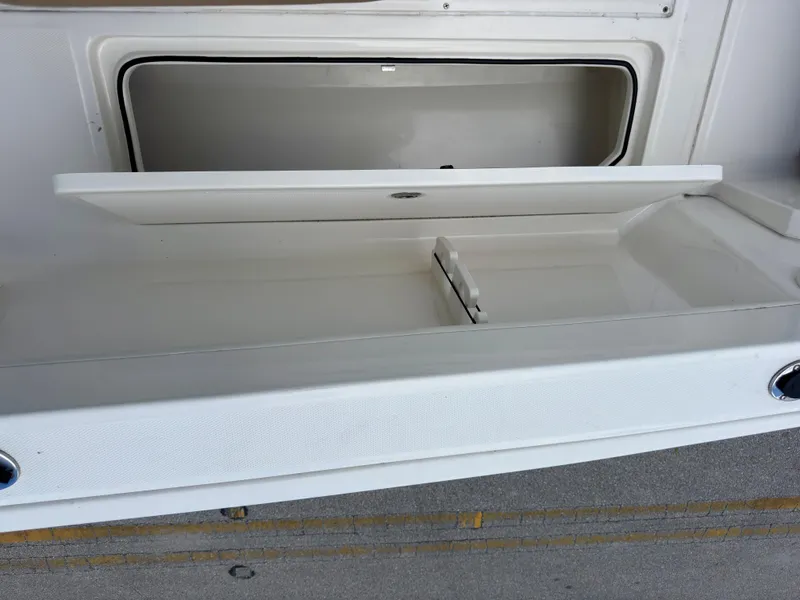 Slide: The Image of 2023 Bayliner Trophy T24CC storage compartment with open lid, showcasing interior space. - 30