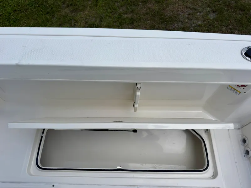 Slide: The Image of 2023 Bayliner Trophy T24CC storage compartment open, showcasing interior space. - 31