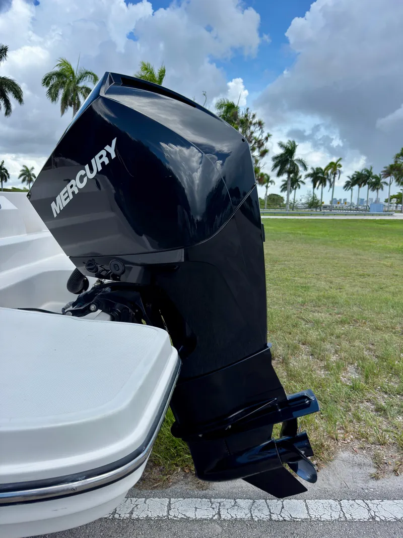 Slide: The Image of 2023 Bayliner Trophy T24CC with Mercury outboard motor, parked on grass under cloudy sky. - 32