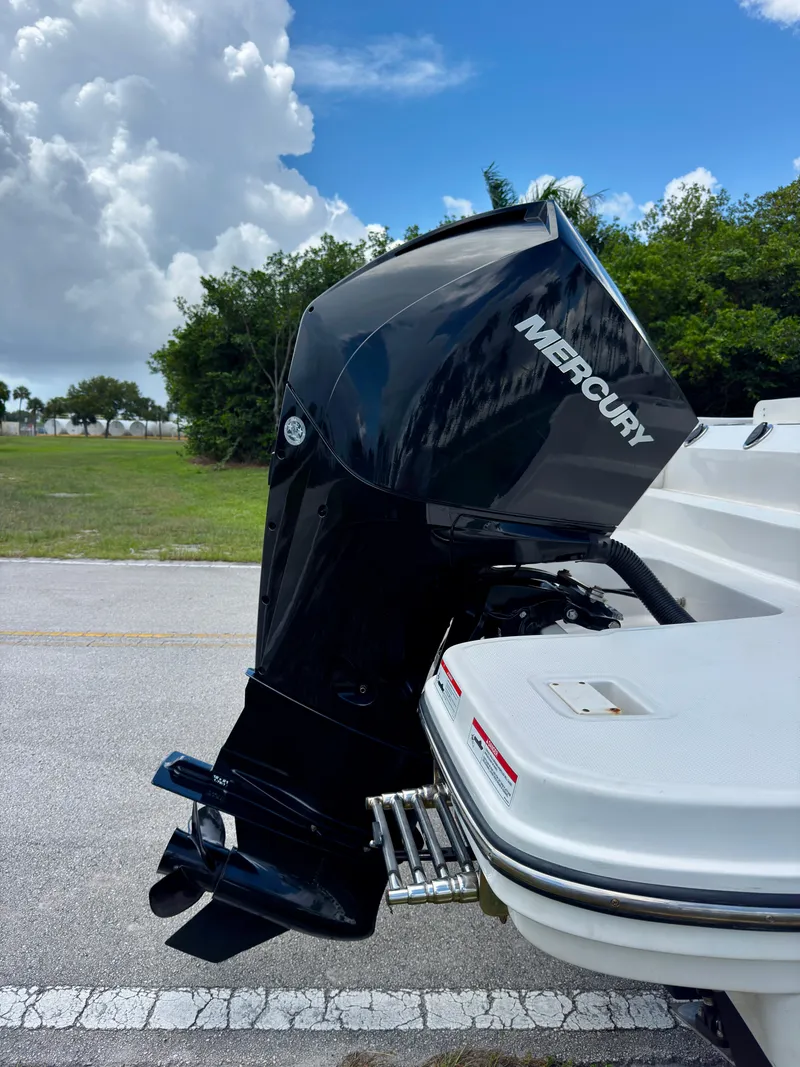 Slide: The Image of 2023 Bayliner Trophy T24CC with Mercury outboard motor, parked outdoors under cloudy sky. - 33