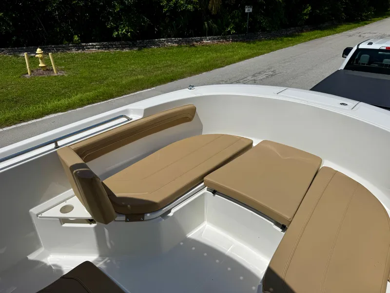 Slide: The Image of 2023 Bayliner Trophy T24CC boat with tan seating, parked on roadside. - 9