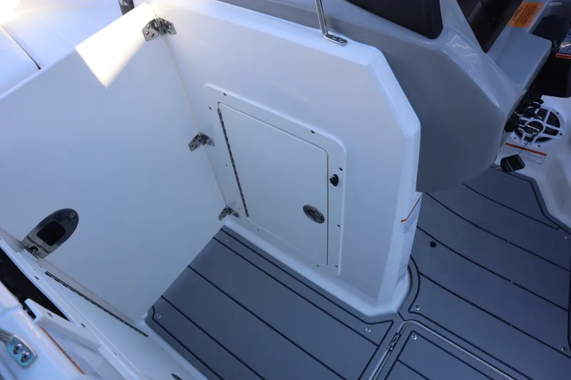 Slide: The Image of 2024 Chaparral 21 SSi Ski & Fish OB interior with storage compartment and gray flooring. - 14