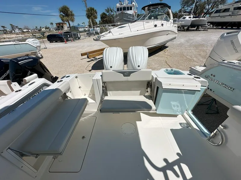 Slide: The Image of 2025 Sailfish 276 DC boat interior with seating and storage, docked in a marina. - 13