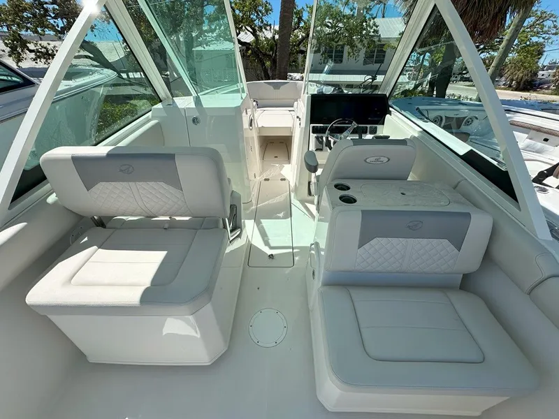 Slide: The Image of 2025 Sailfish 276 DC boat interior with white seating and modern dashboard. - 14