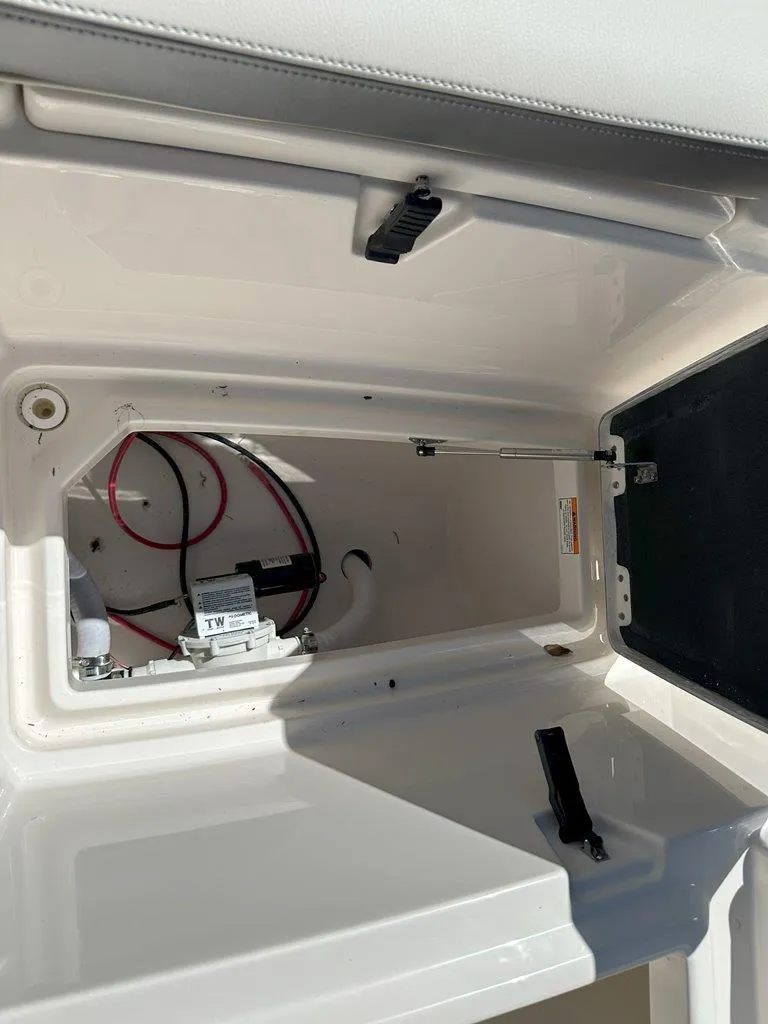 Slide: The Image of Open storage compartment in 2025 Sailfish 276 DC boat, showing interior details and wiring. - 23