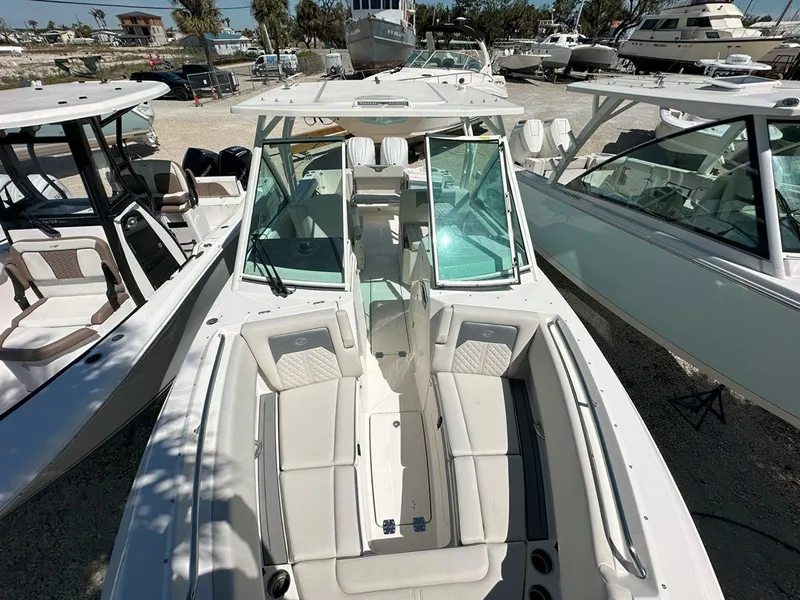 Slide: The Image of 2025 Sailfish 276 DC boat with spacious seating and modern design in a marina setting. - 25