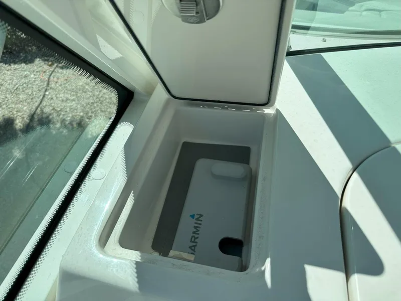 Slide: The Image of Open storage compartment on 2025 Sailfish 276 DC boat with Garmin device inside. - 26