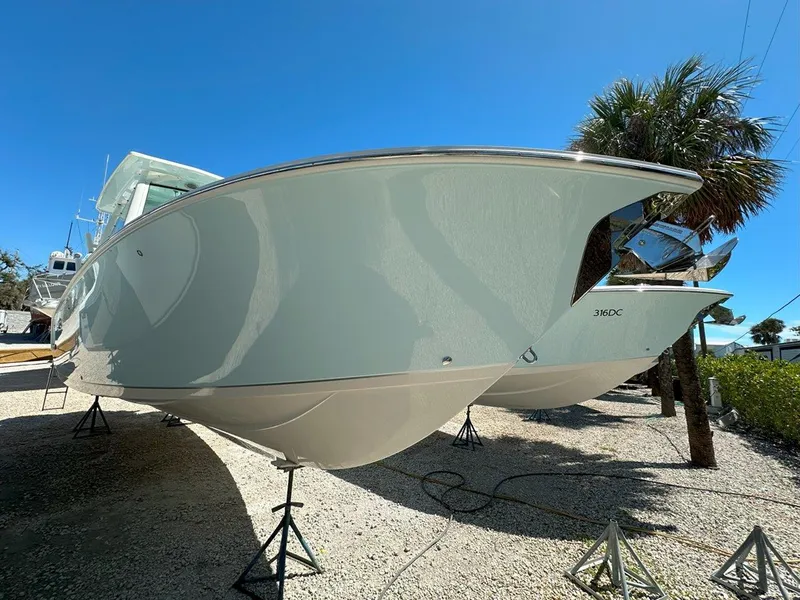 Slide: The Image of 2025 Sailfish 276 DC boat on stands, clear sky, palm trees in background. - 6