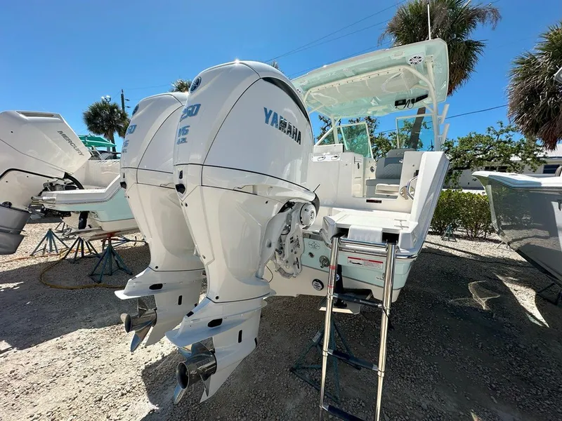 Slide: The Image of 2025 Sailfish 276 DC boat with dual Yamaha outboard engines, parked outdoors. - 7