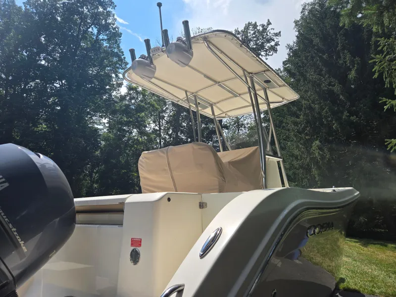 Slide: The Image of 2015 Cobia 201 Center Console boat with canopy, parked outdoors. - 2