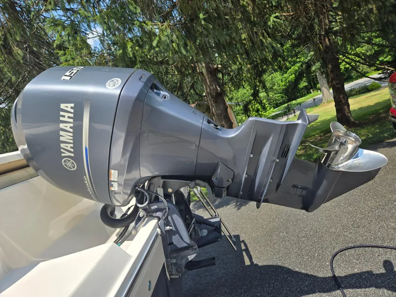 Slide: The Image of 2015 Cobia 201 Center Console with Yamaha outboard motor in a wooded area. - 4