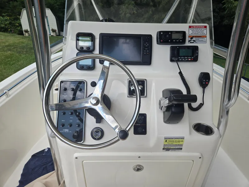 Slide: The Image of 2015 Cobia 201 Center Console boat dashboard with steering wheel and navigation equipment. - 6