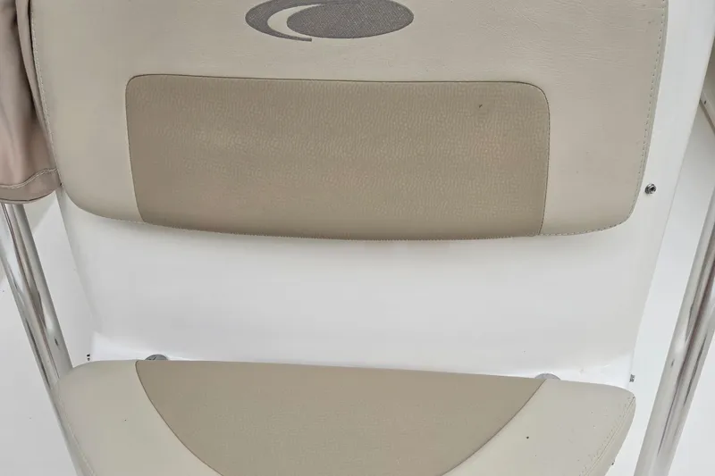 Slide: The Image of Cobia 201 Center Console 2015 boat seat with beige upholstery and logo. - 9