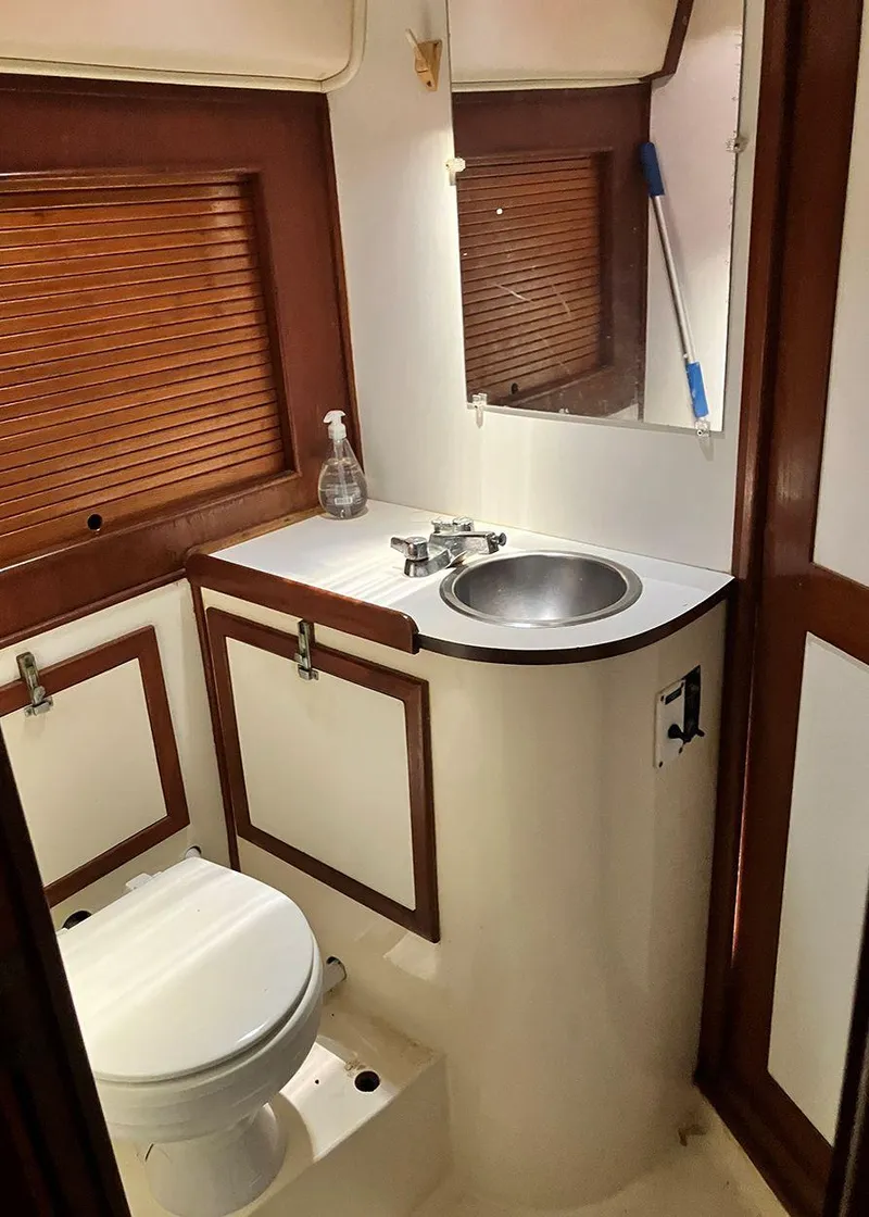 Slide: The Image of 2002 Jeanneau 43DS yacht bathroom with sink, toilet, and wooden accents. - 14