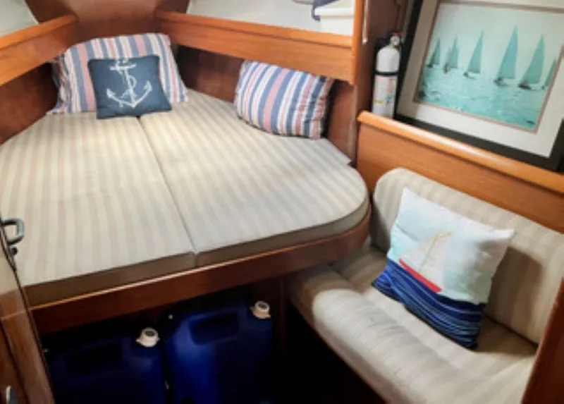 Slide: The Image of Cozy cabin interior of 2002 Jeanneau 43DS sailboat with nautical decor and striped cushions. - 15