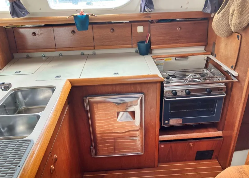 Slide: The Image of Galley kitchen in 2002 Jeanneau 43DS sailboat with stove, sink, and storage. - 9