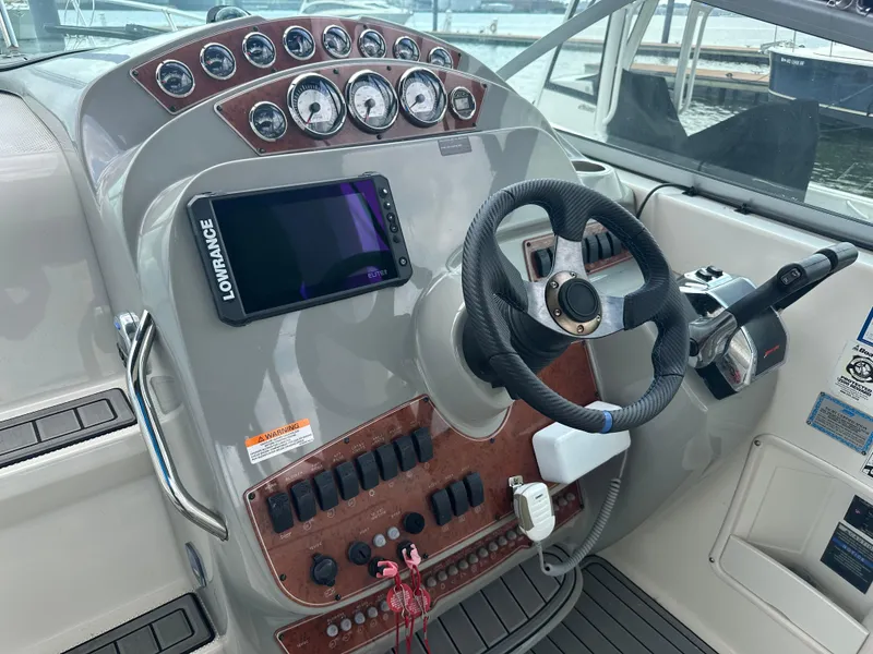 Slide: The Image of Control panel of a 2008 Bayliner 300SB boat with steering wheel and navigation equipment. - 10