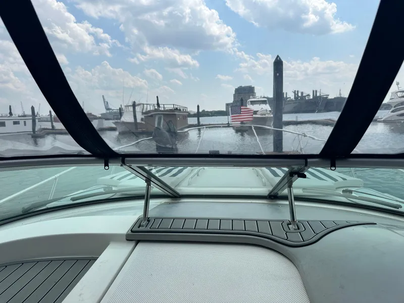 Slide: The Image of 2008 Bayliner 300SB boat view from cockpit, marina in background, partly cloudy sky. - 13