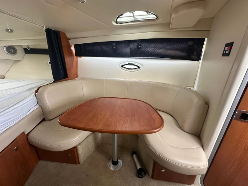 Slide: The Image of Interior of 2008 Bayliner 300SB boat with cozy seating and wooden table. - 17