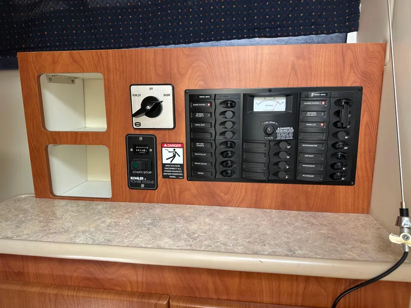 Slide: The Image of Electrical control panel on a 2008 Bayliner 300SB boat, featuring switches and gauges. - 22